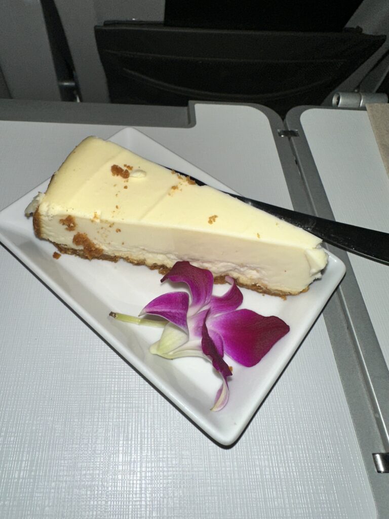 a slice of cheesecake on a plate with a flower