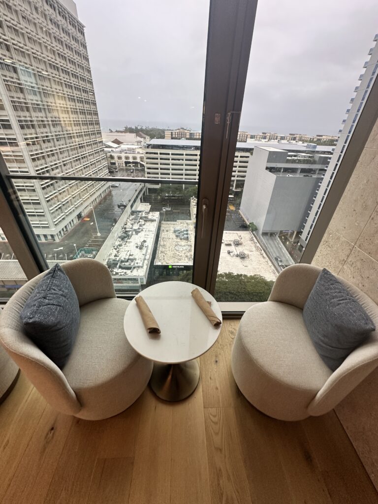 two chairs and a table in a room with a view of a city