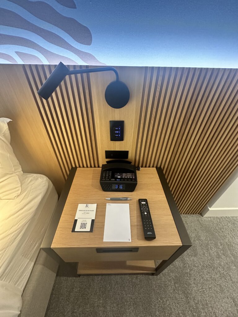 a desk with a phone and remote control