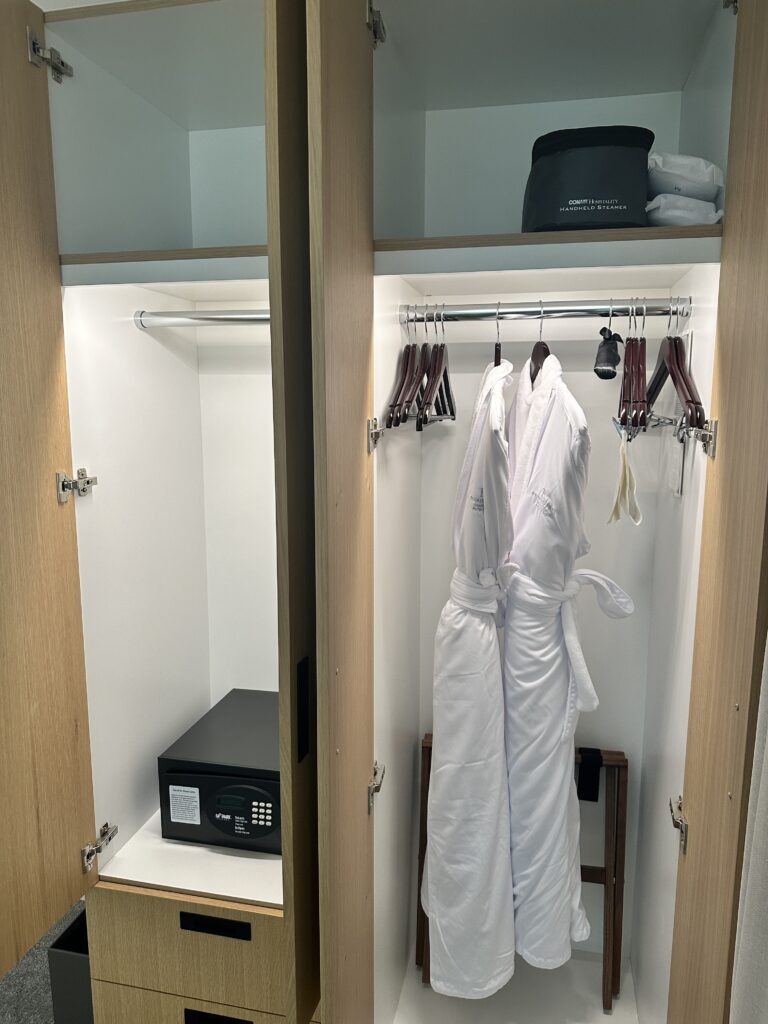 a closet with white robes and a safe