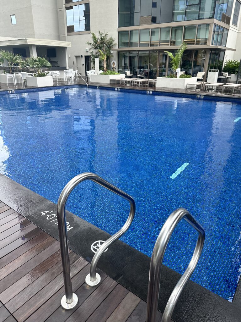 a swimming pool with a deck and chairs