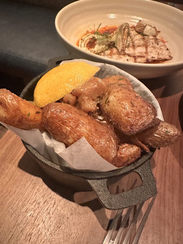 a pan of food with a lemon wedge and a plate of food