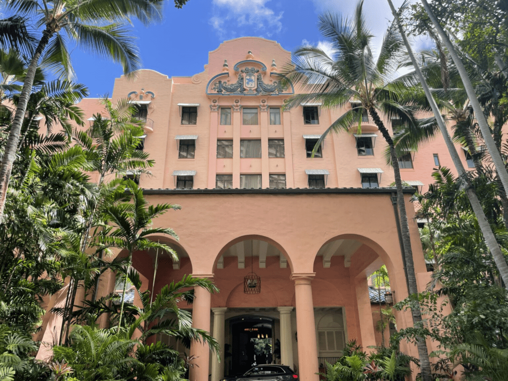 a building with palm trees and a car parked in front of it