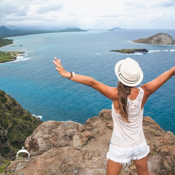 a woman standing on a cliff overlooking a body of water