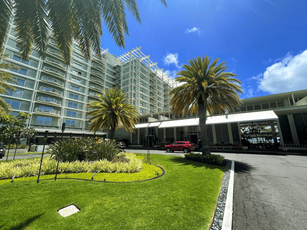 a building with palm trees and a parking lot