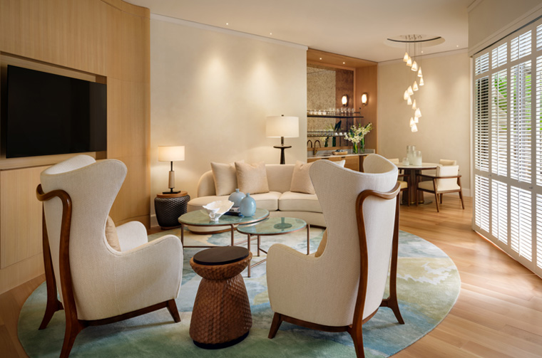 a living room with white chairs and a table