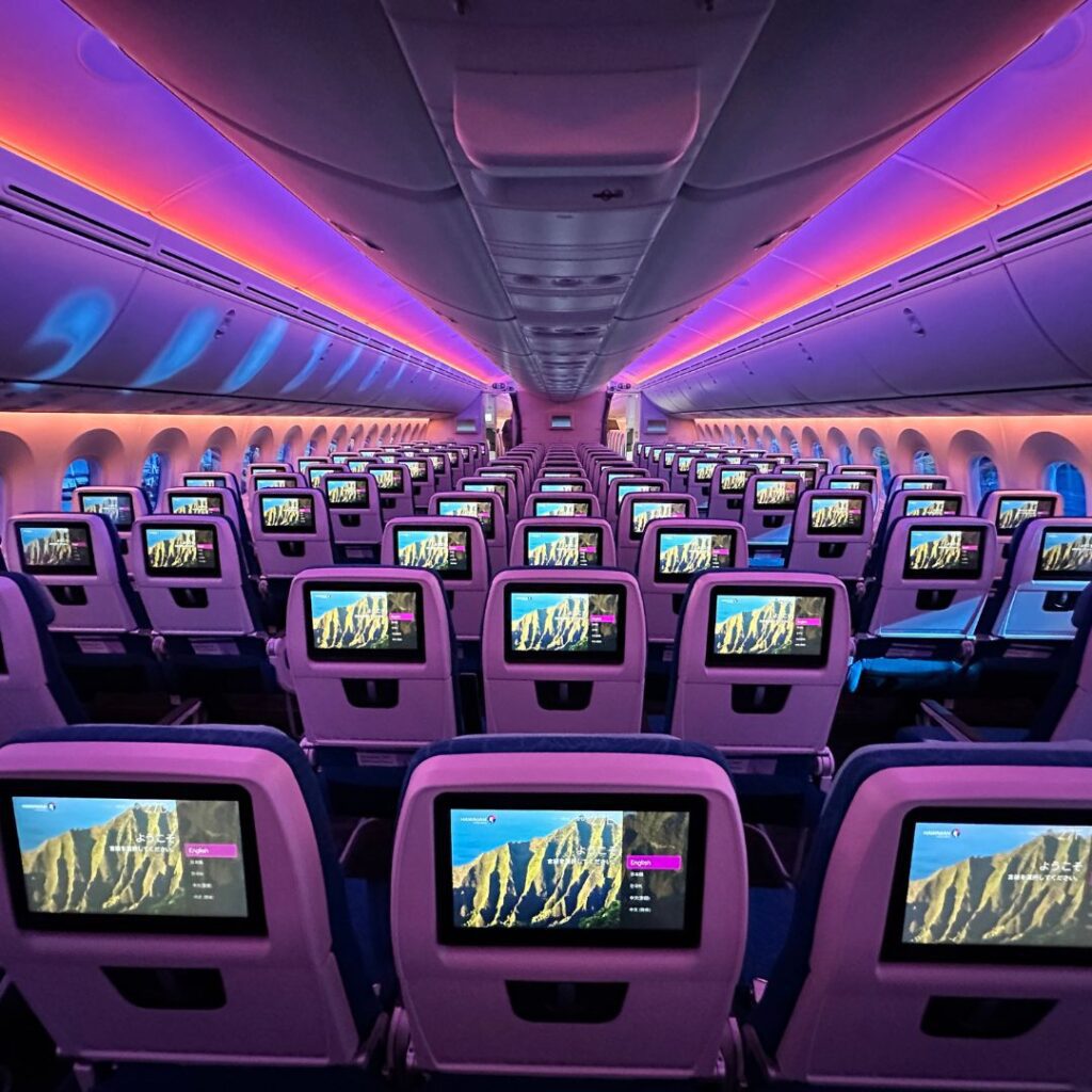 rows of seats with monitors in the back to keep you entertained on long flights to Hawai'i 