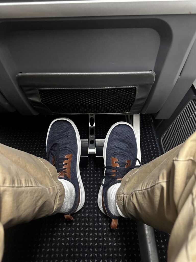 a person's legs and feet in a seat