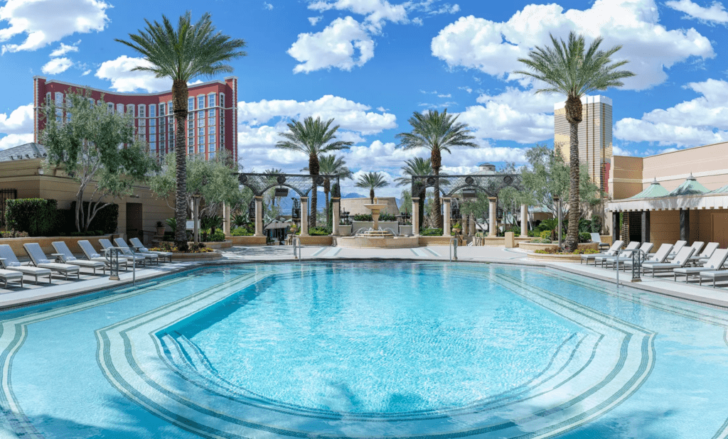 a pool with palm trees and a building in the background