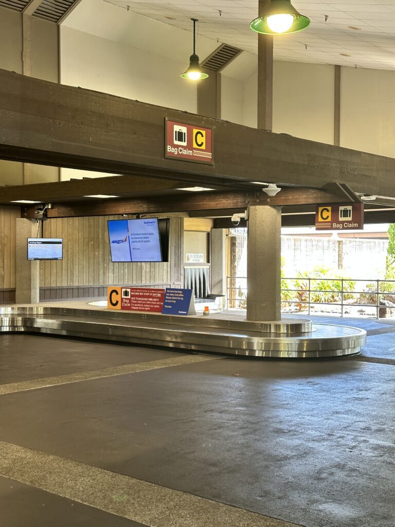 a baggage claim area with a sign