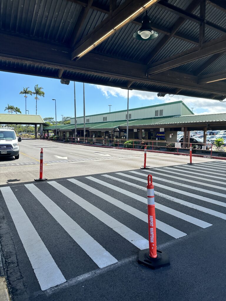 a crosswalk with a car parked in the background