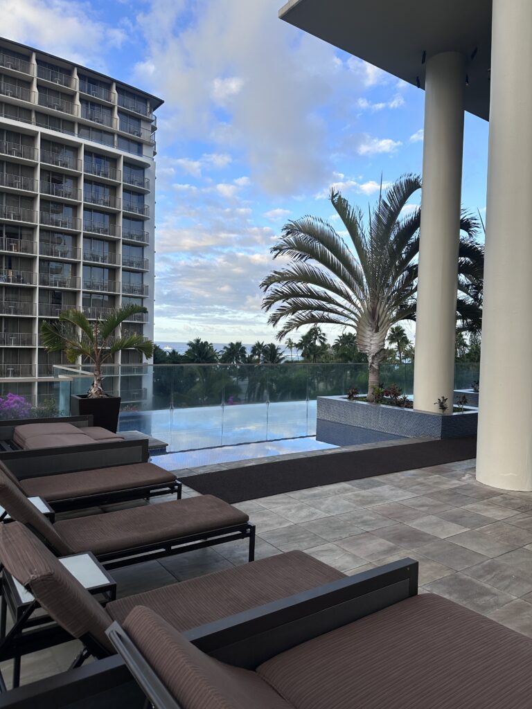 a deck with chairs and palm trees