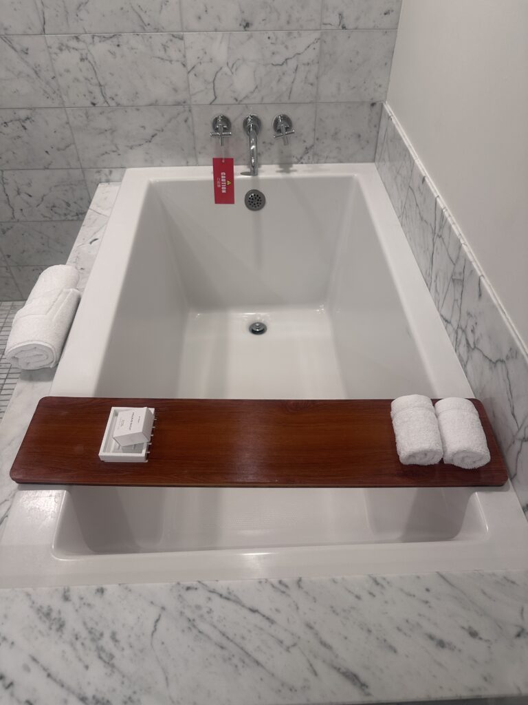 a bathtub with a tray and towels on it