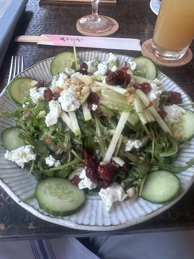 a plate of salad with cucumbers and cranberries