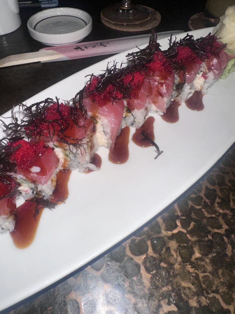 a plate of sushi with sauce on it