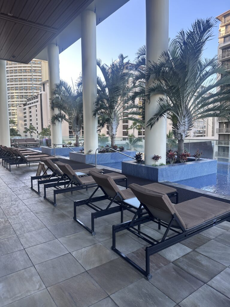 a pool with lounge chairs and palm trees