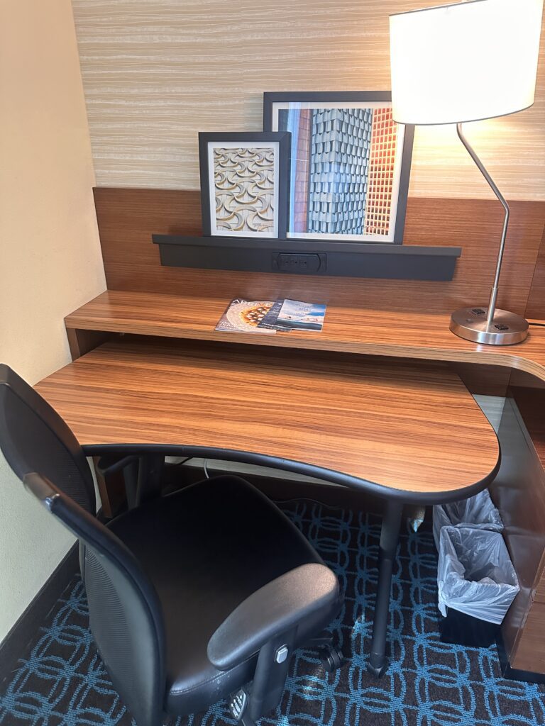 a desk with a lamp and a picture frame