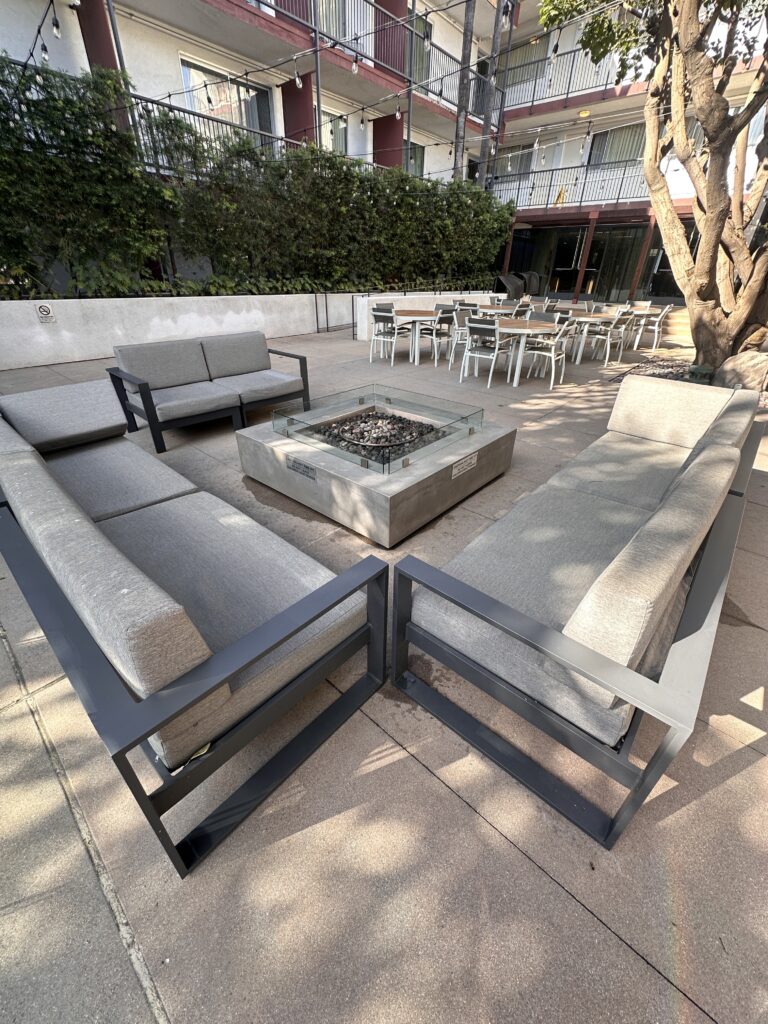 a patio with a fire pit and couches