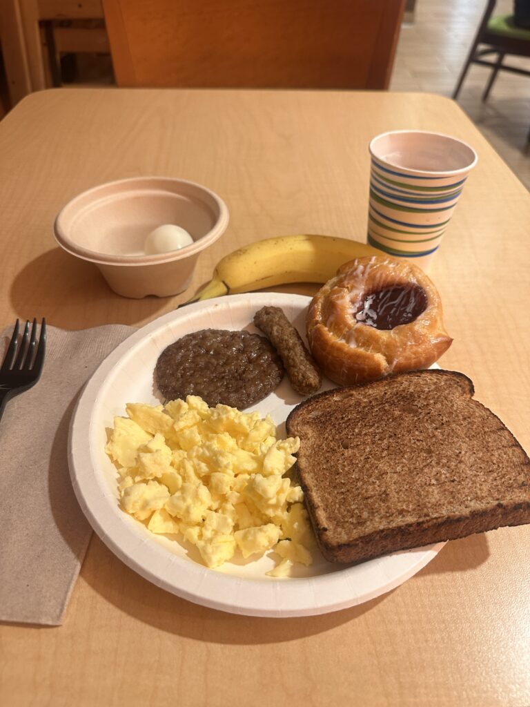 a plate of breakfast with eggs toast and sausage