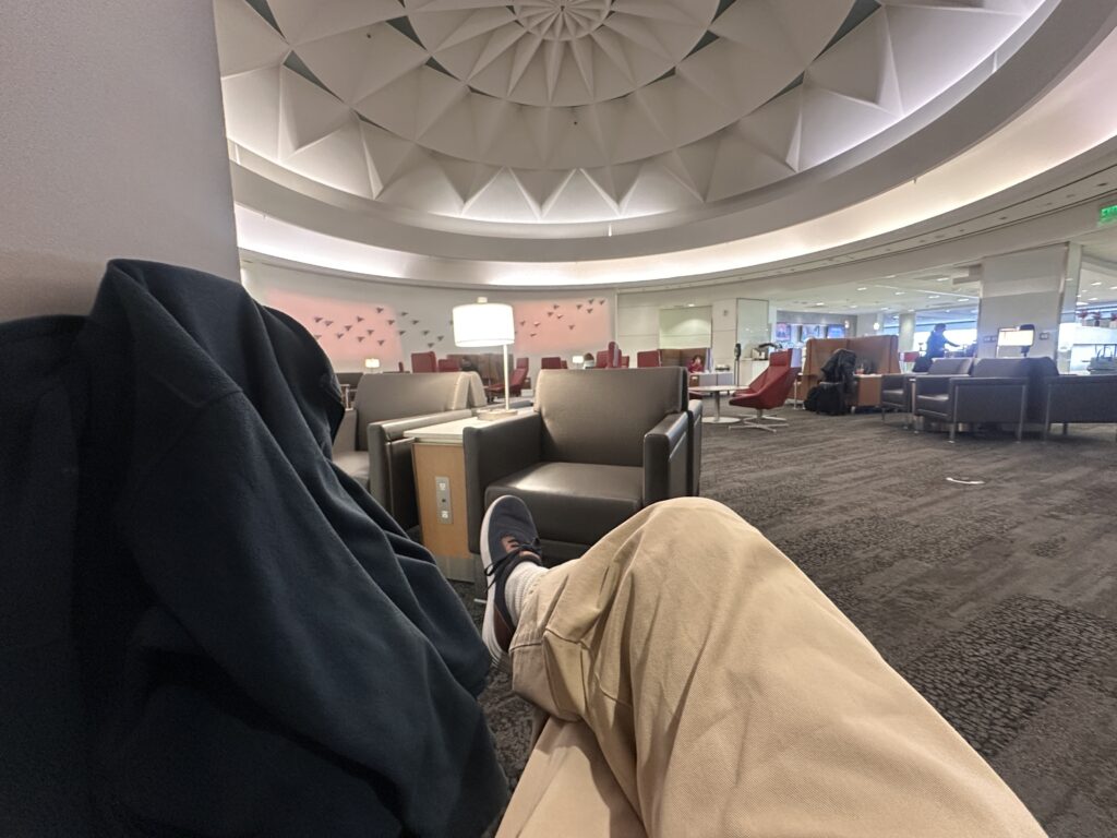 a person's legs in a room with a ceiling and chairs