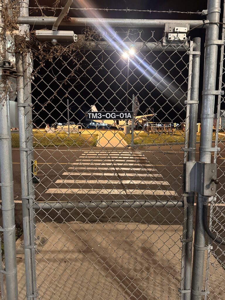 a gate with a sign and a street light