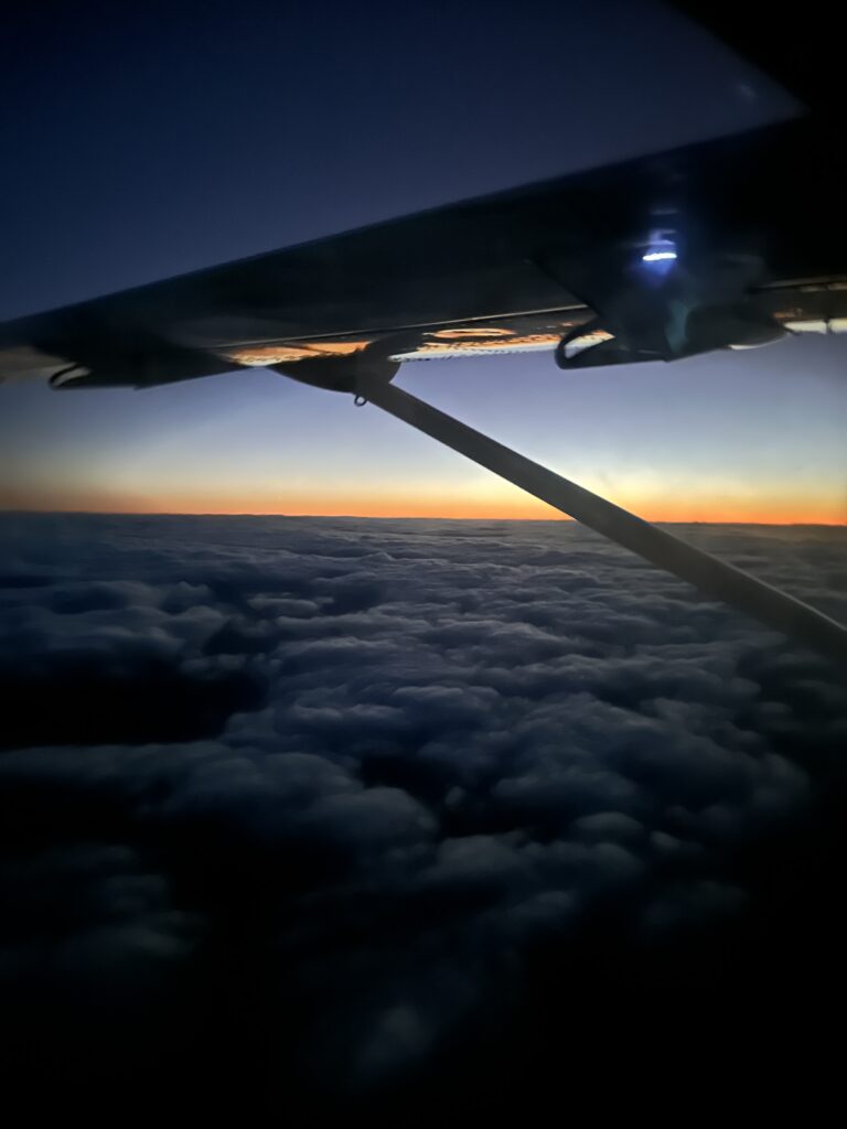 an wing of an airplane above the clouds